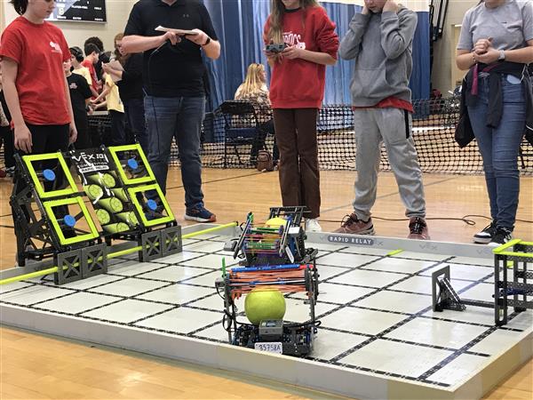 Robots are on a field at a VEX IQ competition.